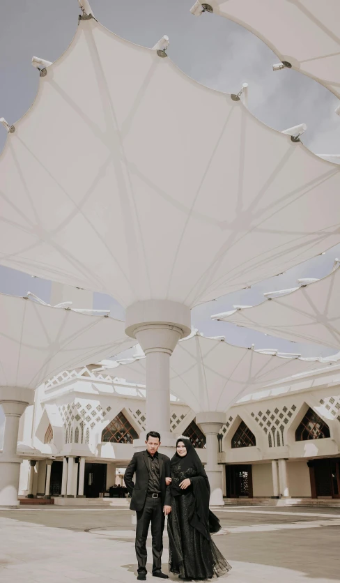 a man and a woman standing in front of a building, by Basuki Abdullah, unsplash contest winner, hurufiyya, complex ceiling, low quality photo, square, pavilion