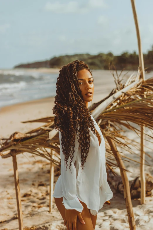 a woman standing on top of a sandy beach, long braided curly hair, colombian, 5 0 0 px models, african