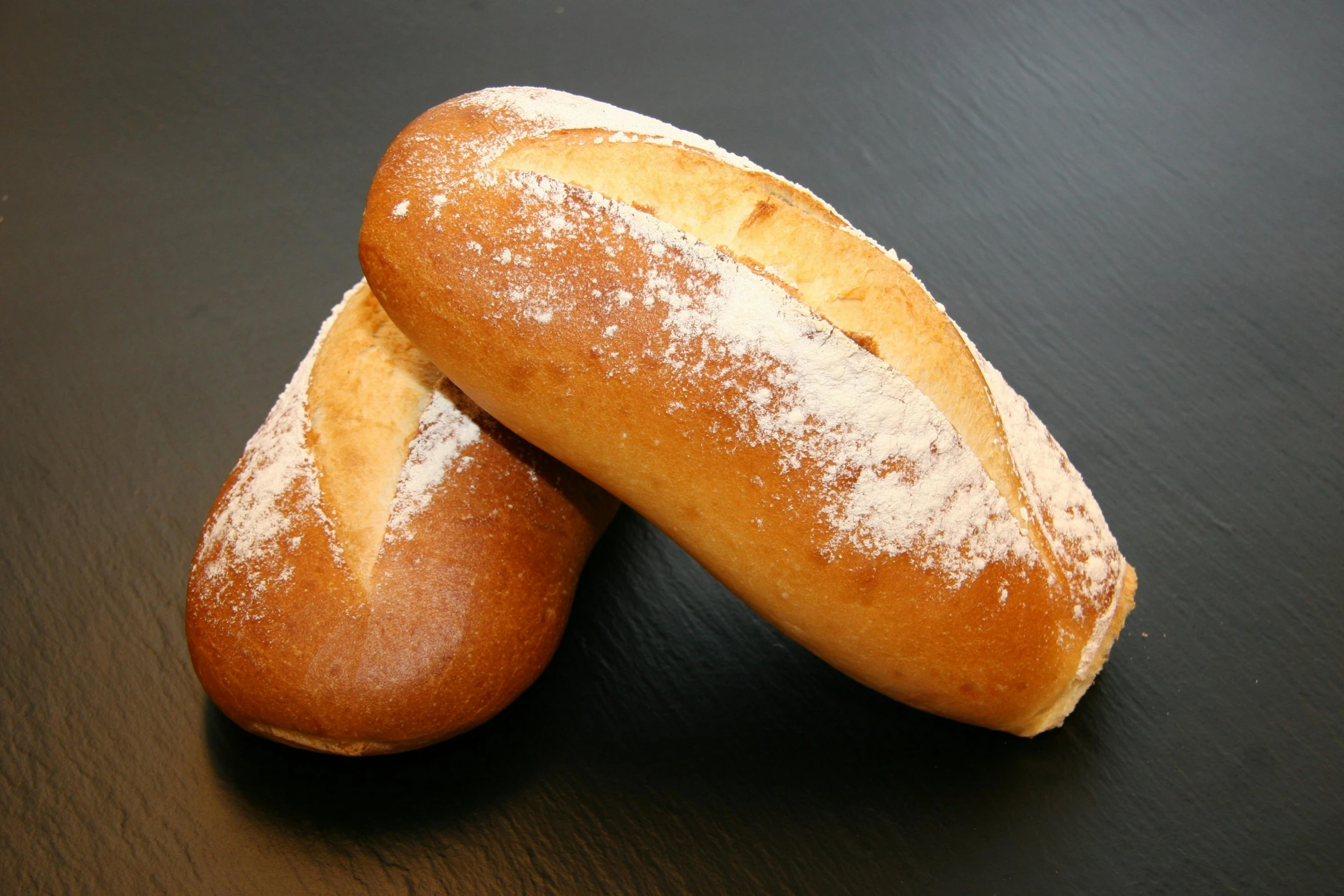 two loaves sitting next to each other on a table, high quality product image”, pointè pose, in a medium full shot, pastry