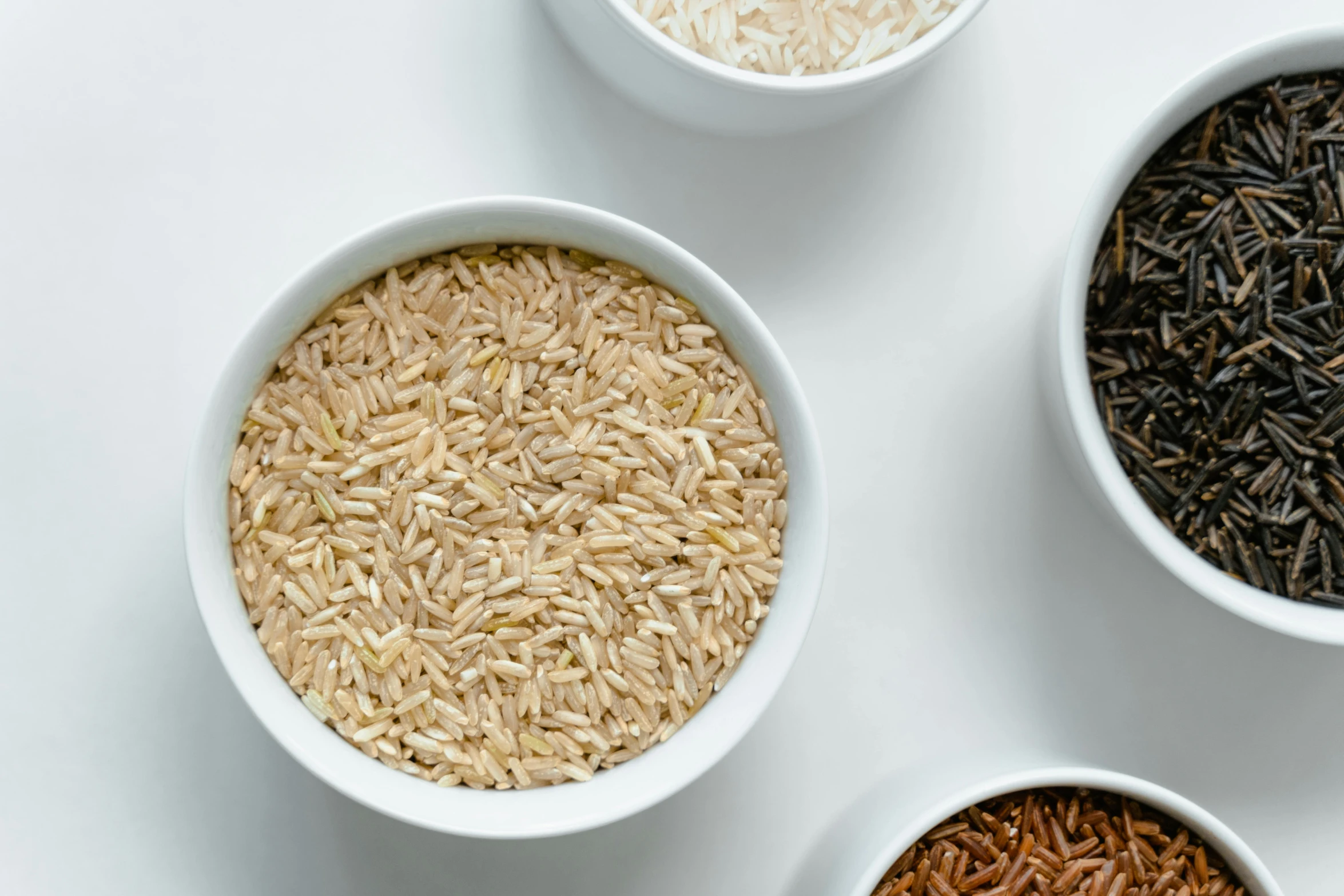 four bowls filled with different types of rice, a digital rendering, trending on pexels, light tan, trending on dezeen, on a white table, organic detail