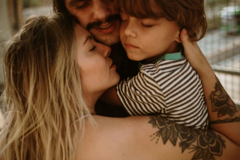 a man holding a little boy in his arms, a tattoo, by Nándor Katona, pexels contest winner, portrait of family of three, couple kissing, avatar image, middle close up