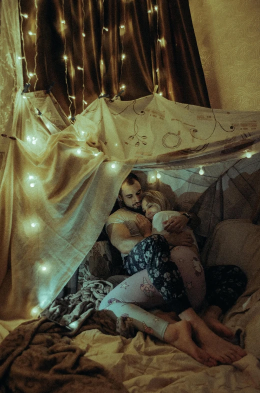 a couple of people laying on top of a bed, fairy lights, fatherly, interior of a tent, profile image