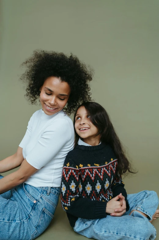 a woman and a little girl sitting on the floor, wearing a green sweater, long afro hair, supportive, jen atkin