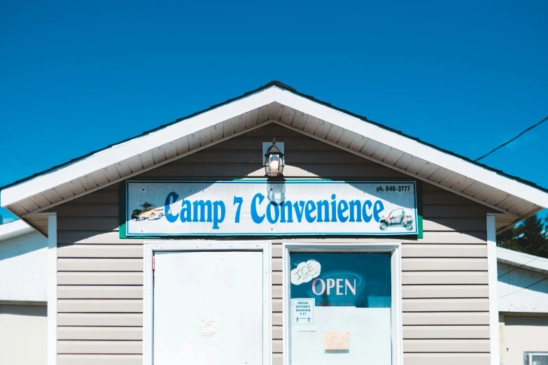 a building with a sign that says camp 7 convenience, an album cover, unsplash, profile image, stålenhag, new hampshire, comedic