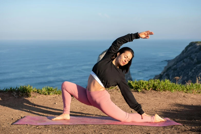 a woman doing a yoga pose in front of the ocean, pexels contest winner, arabesque, avatar image, sport clothing, outside on the ground, longque chen