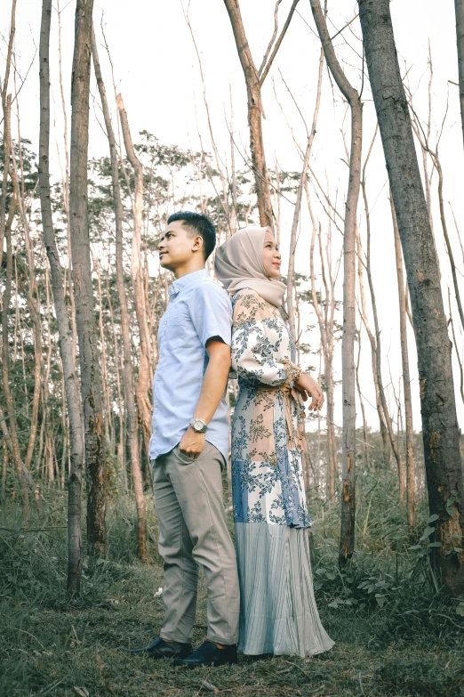 a man and woman standing next to each other in a forest, a picture, by Basuki Abdullah, unsplash, hurufiyya, grey and blue theme, square, album, ( ( theatrical ) )