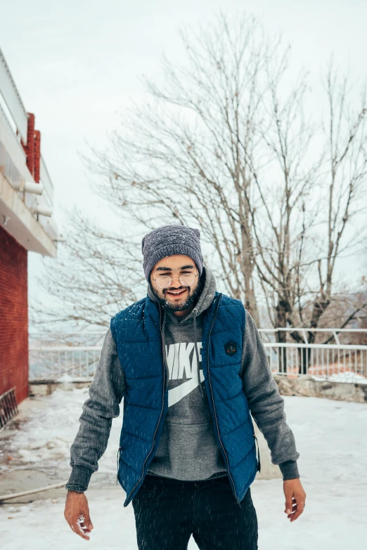 a man riding a skateboard down a snow covered street, a colorized photo, pexels contest winner, portrait of jughead jones, blue hoodie, sayem reza, welcoming grin