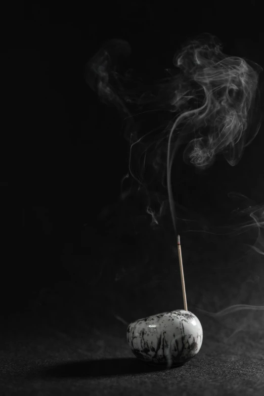 a black and white photo of a incense stick, an album cover, unsplash, conceptual art, smoking rock, raku, ignant, paul barson