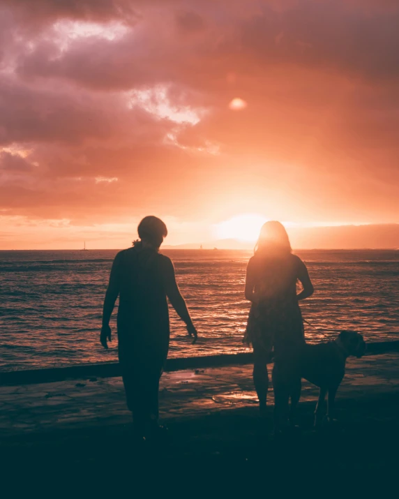 two people and a dog on a beach at sunset, pexels contest winner, lgbt, how pretty