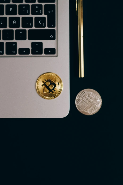 a laptop computer sitting on top of a desk next to a coin, by Adam Rex, trending on unsplash, renaissance, edible crypto, minimalist sticker, gold and black blu, set against a white background