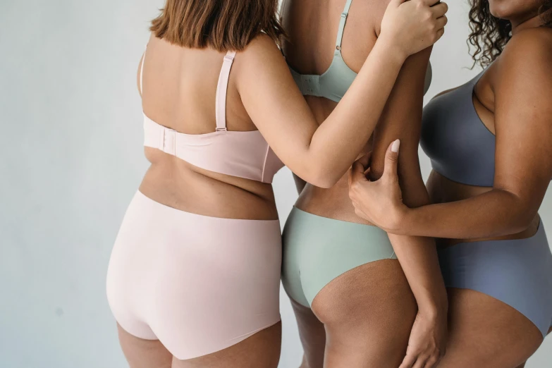 three women in underwear standing next to each other, trending on pexels, eucalyptus, pastelcolours, showing curves, piled around