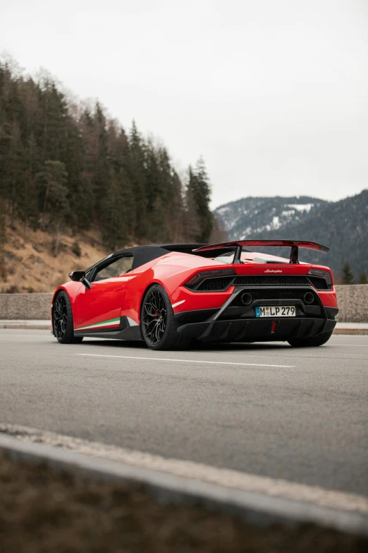 a red sports car driving down a road, by Daniel Seghers, pexels contest winner, baroque, mountain in the background, black steel with red trim, 🚿🗝📝, lamborghini