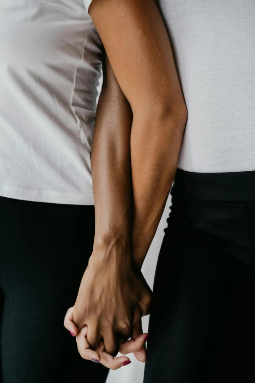 a man and a woman holding hands, by Nina Hamnett, unsplash, arms crossed on chest, non binary model, two men hugging, white sleeves