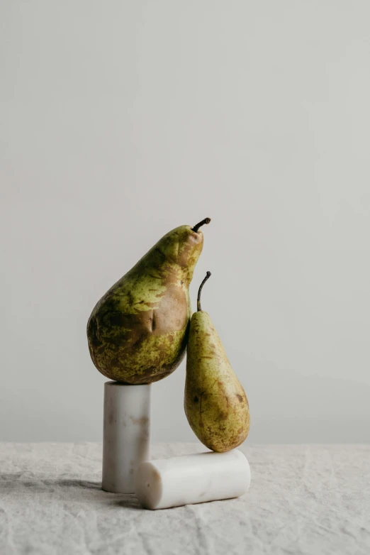 two pears sitting on top of a marble block, by Kristin Nelson, trending on pexels, portrait of tall, vegetable, dynamic pose, jisu choe