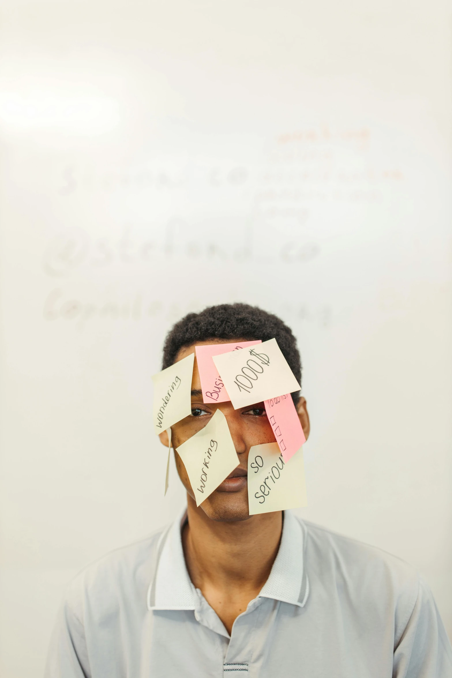 a man standing in front of a whiteboard covered in post it notes, an album cover, pexels, broken mask, black teenage boy, face partially obscured, stacked image