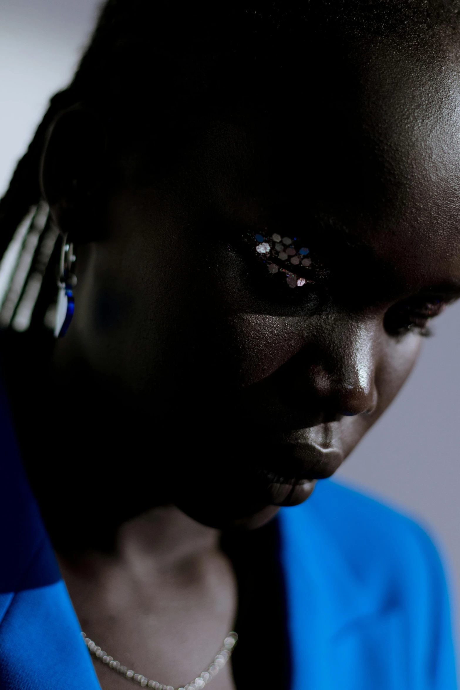 a close up of a person with a cell phone, an album cover, adut akech, ((blue)), shot at dark with studio lights, african ameera al taweel