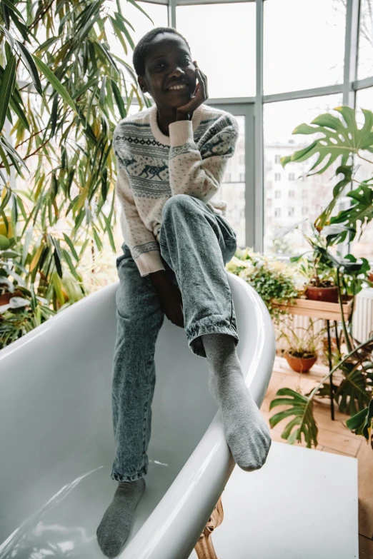 a man sitting in a bathtub talking on a cell phone, by Matija Jama, trending on unsplash, tall plants, wearing casual sweater, feet posing, confident pose