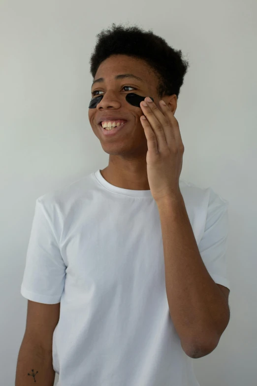 a close up of a person talking on a cell phone, black eye mask, black teenage boy, photoshoot for skincare brand, smiling slightly