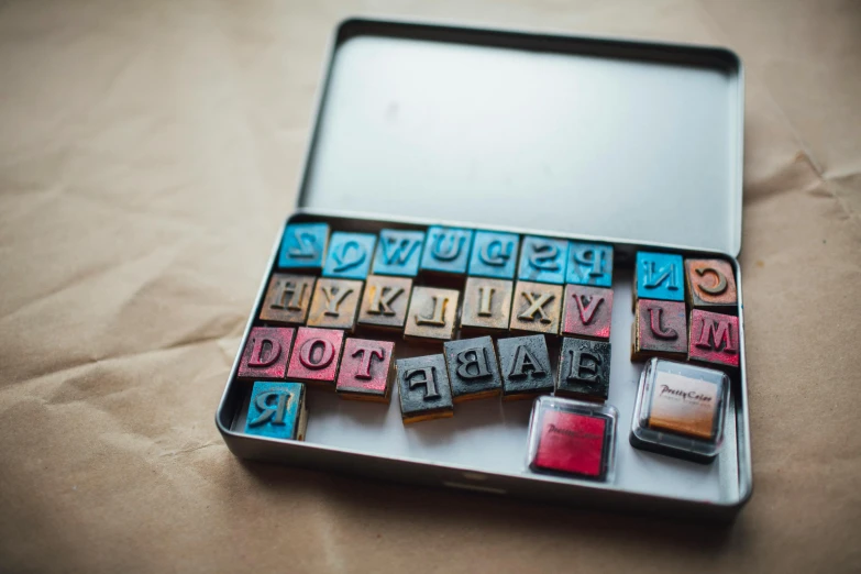 a laptop computer sitting on top of a table, by Emma Andijewska, pexels contest winner, letterism, r / paintedminis, blocks, treasures, teacher