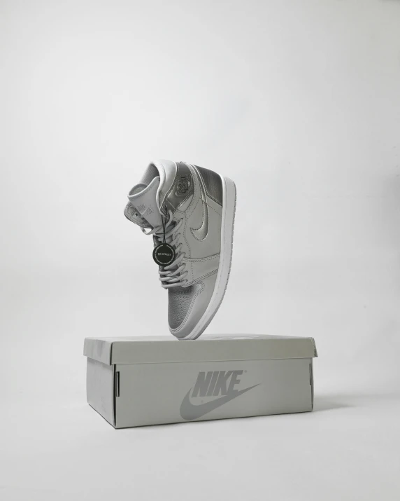 a pair of sneakers sitting on top of a box, a hologram, gun metal grey, official product photo, ƒ/2.5, flat grey