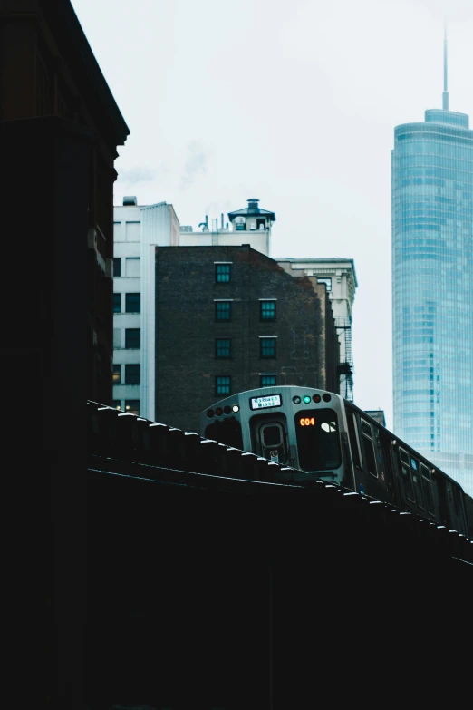 a train traveling through a city next to tall buildings, by Carey Morris, unsplash contest winner, hiding in the rooftops, mta subway entrance, promo image, seen from the side