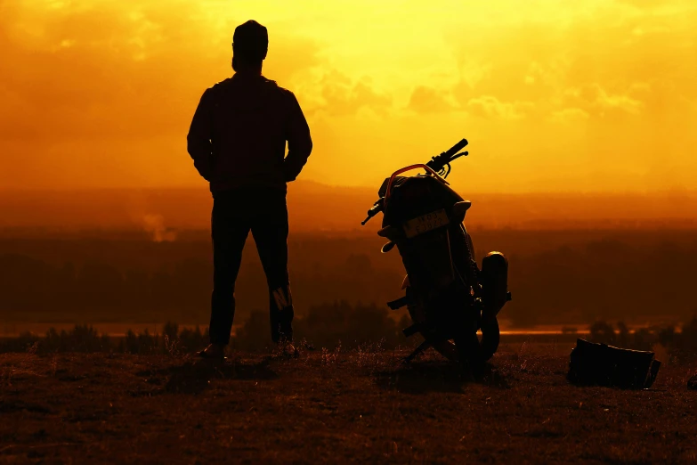 a man standing next to a motorcycle on top of a grass covered field, pexels contest winner, romanticism, silhouette :7, avatar image, gazing off into the horizon, friendship