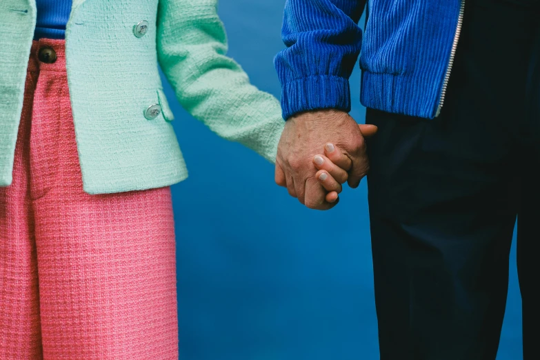 a close up of two people holding hands, by Anna Findlay, wearing a blue jacket, colourful clothes, older male, colour photography