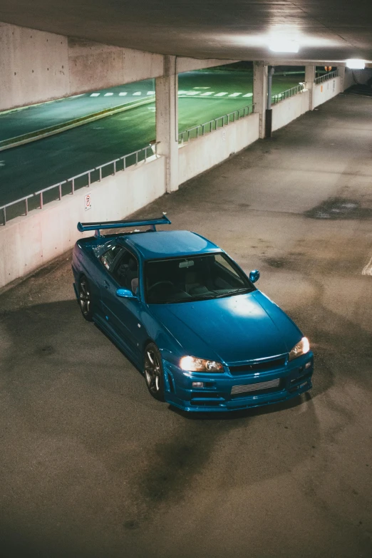 a blue car parked in a parking garage, by An Gyeon, pexels contest winner, in a modified nissan skyline r34, top down lighting, full body shot 4k, instagram post