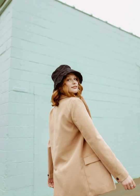 a woman walking down a sidewalk carrying a suitcase, unsplash, renaissance, black stetson and coat, ginger hair, profile image, pastel clothing