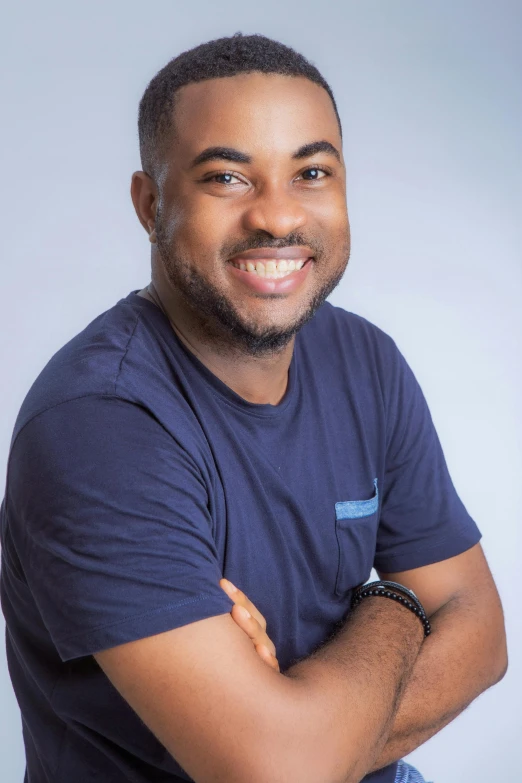 a man in a blue shirt posing for a picture, by Chinwe Chukwuogo-Roy, clear background, a high angle shot, chilled out smirk on face, professional photo-n 3