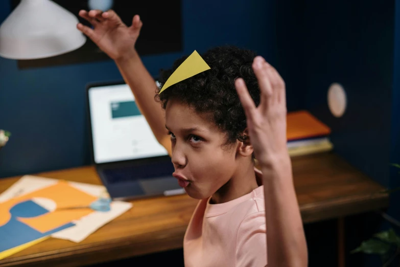 a little girl with a paper crown on her head, pexels contest winner, happening, in front of a computer, hard angles, with arms up, avatar image