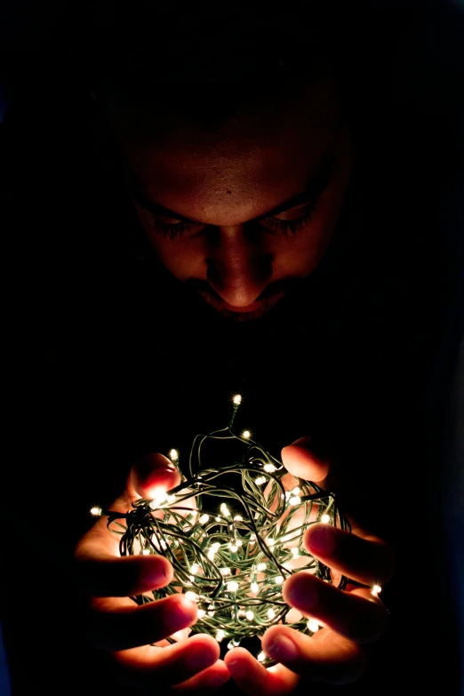 a person holding a string of lights in their hands, a portrait, by Adam Chmielowski, screensaver, dramatic lighting !n-9, holiday season, engineer