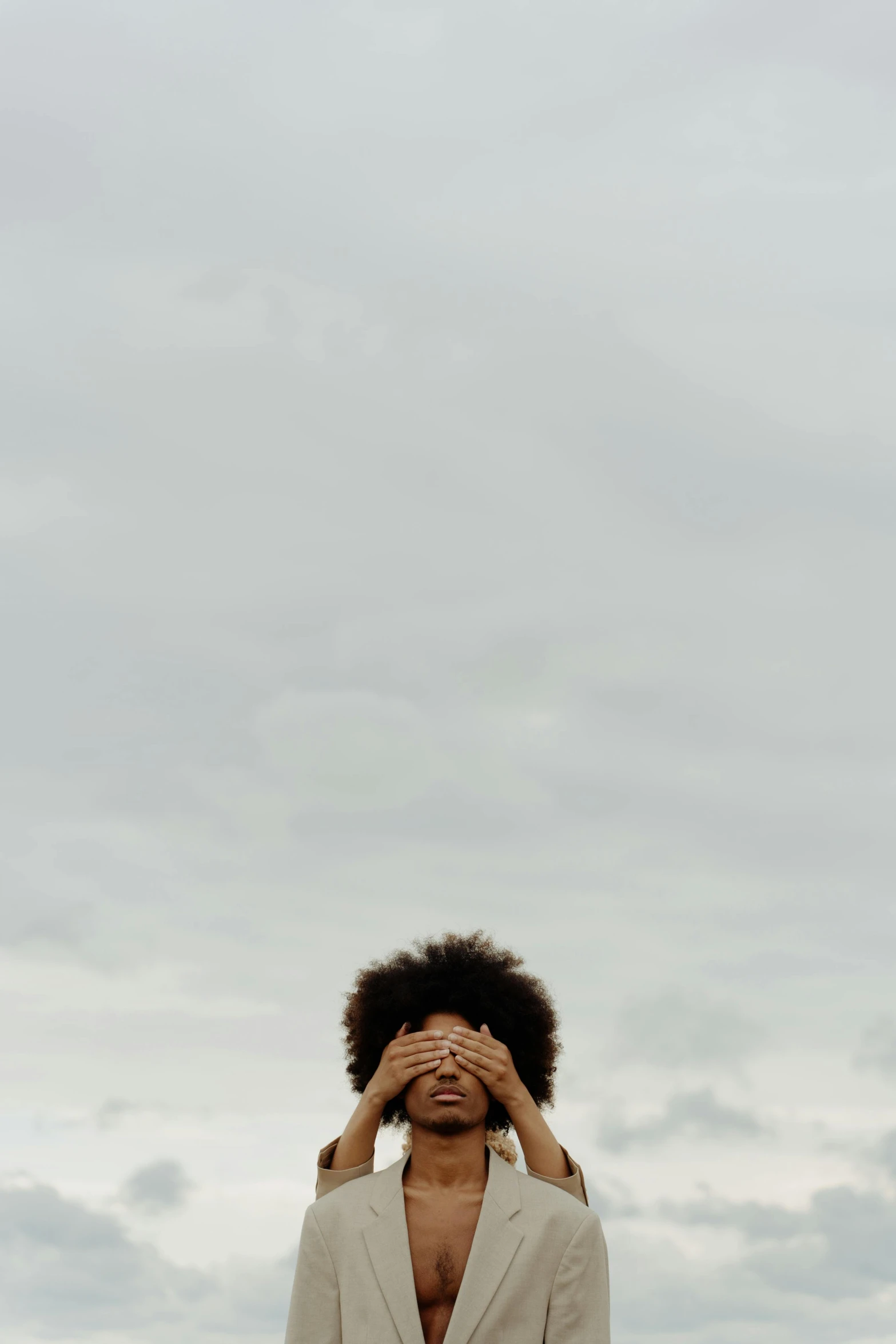 a man standing on top of a sandy beach, by Carey Morris, pexels contest winner, god ray across her face, afro tech, on a gray background, hands straight down