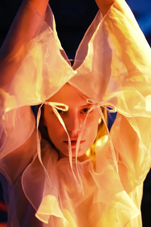a close up of a person holding a frisbee, inspired by Cindy Sherman, renaissance, soft butterfly lighting, flowing golden scarf, aura jared and wires, wearing organza gown