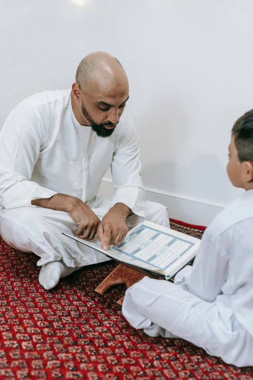 a man sitting on the floor next to a little boy, hurufiyya, grading, islamic, professional image, gif