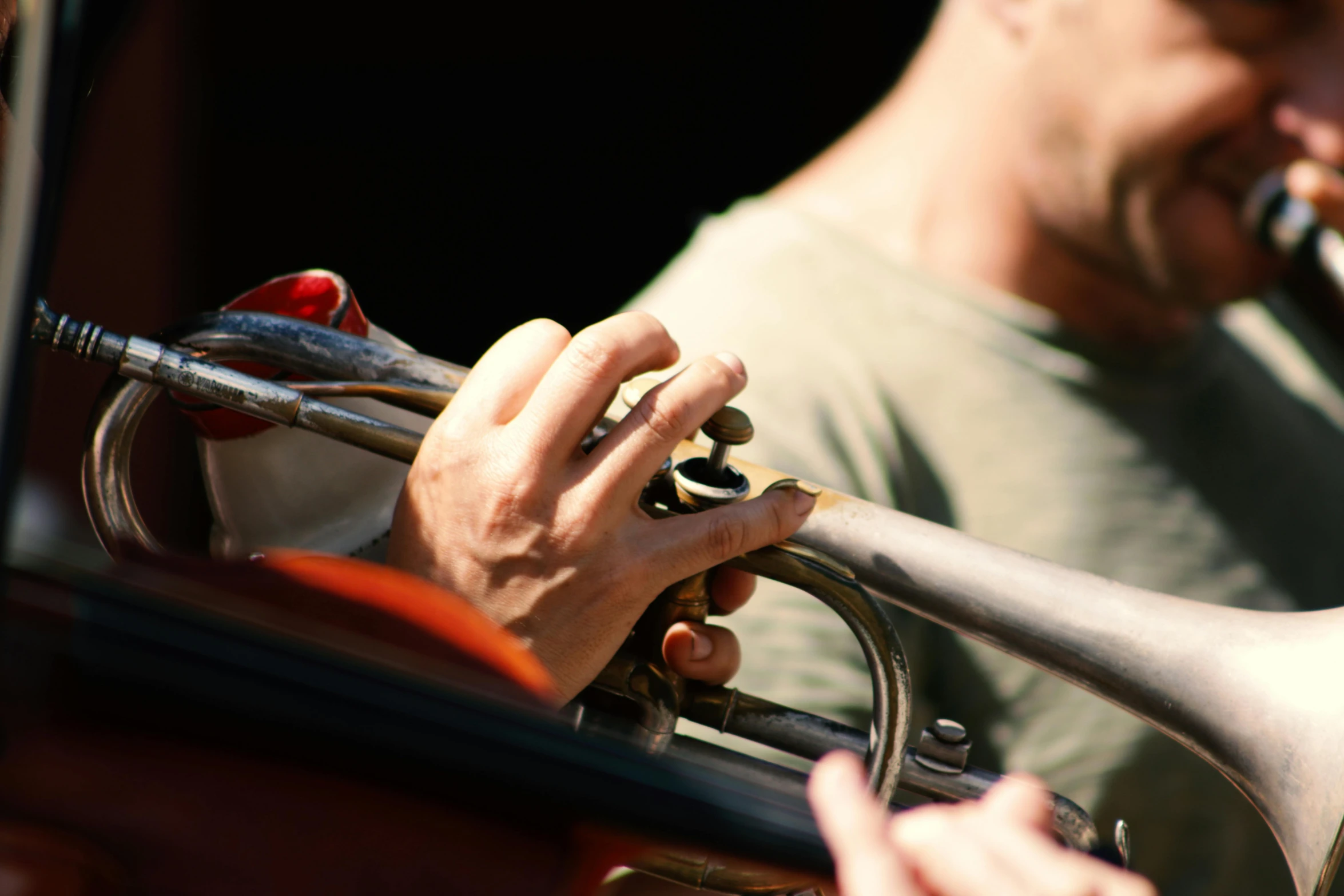 a close up of a person playing a trumpet, pexels, photorealism, coloured, slightly muscular, focus on the musicians, pitch bending