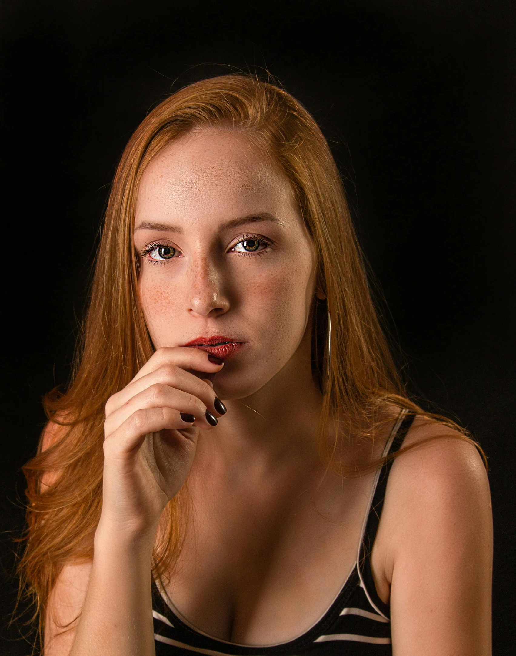 a woman sitting at a table with a cell phone in her hand, a character portrait, by Brian Thomas, pexels contest winner, she is wearing a black tank top, ( redhead, 🤤 girl portrait, black backdrop
