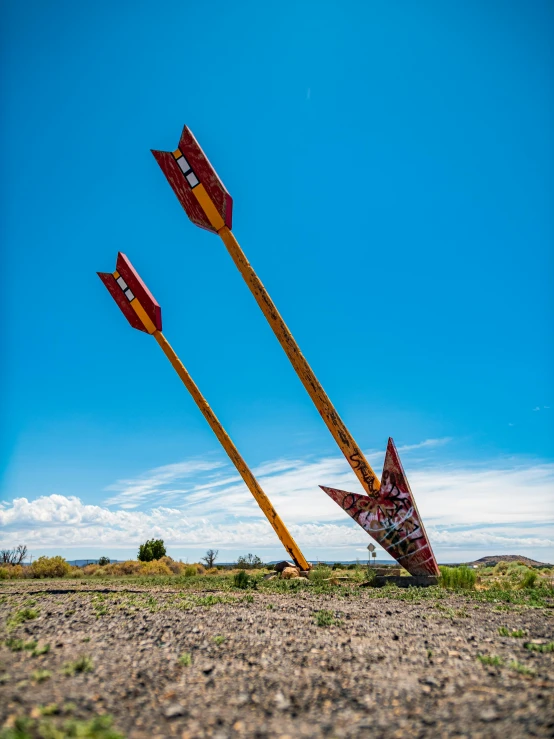 three arrows sticking out of the ground, by Arnie Swekel, pexels contest winner, land art, atomic age maximalist, albuquerque, rockets, 7 feet tall