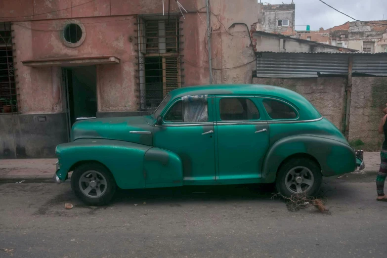 an old green car parked on the side of the road, by Tom Wänerstrand, square, on an indian street, restoration, photo taken in 2018