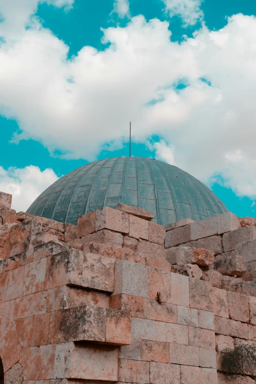 a large stone building with a dome on top of it, by Saul Yaffie, trending on unsplash, crumbled wall in jerusalem, sky blue, covered, instagram picture