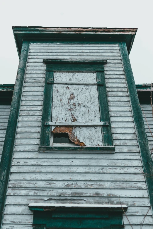 a close up of a building with a broken window, inspired by Andrew Wyeth, unsplash, low quality photo, wooden structures, sickly green colors, seaside victorian building