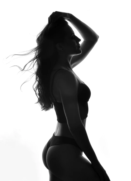 a black and white photo of a woman in a bikini, a black and white photo, pexels contest winner, elegant profile pose, black silhouette, underwear ad, backlit!!