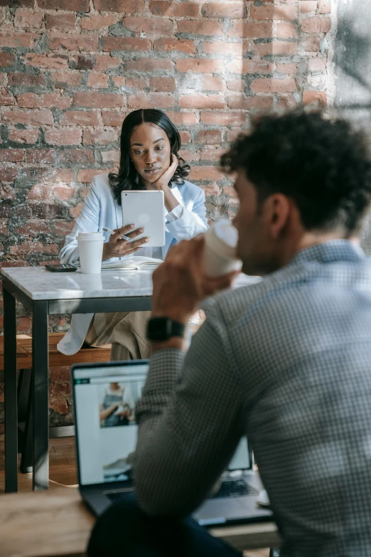 a group of people sitting around a table with laptops, trending on pexels, medium shot of two characters, essence, woman drinking coffee, someone lost job