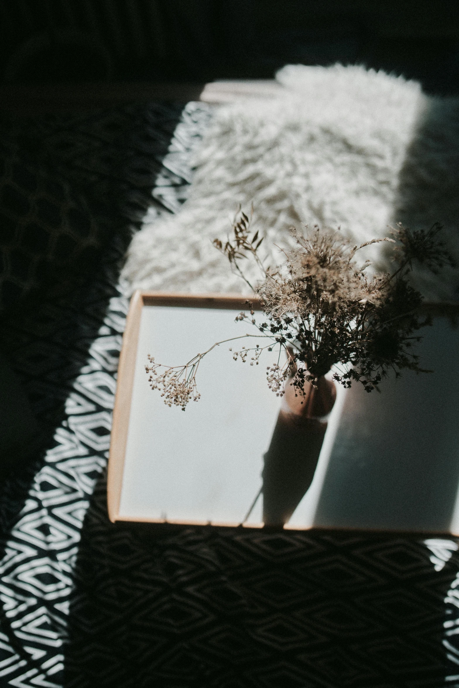 an open book sitting on top of a table, unsplash contest winner, light and space, sitting with flowers, shadow play, light boho carpet, minimalist photo