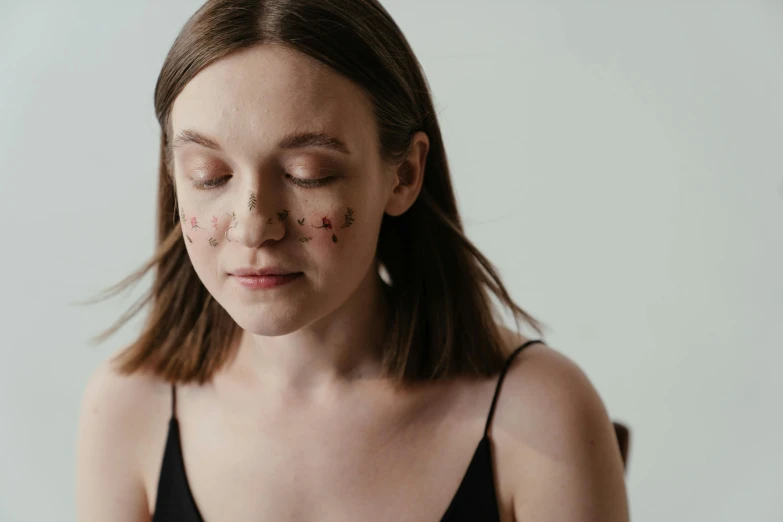 a woman sitting at a table with a plate of food, trending on pexels, hyperrealism, black scars on her face, covered in oil, on grey background, bark for skin