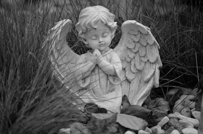 a black and white photo of a statue of an angel, a statue, by Marie Angel, fine art, children's, on ground, he is greeting you warmly, detailed surroundings