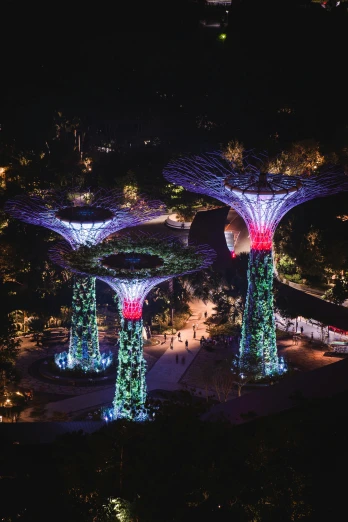 an aerial view of gardens by the bay at night, a digital rendering, pexels contest winner, environmental art, tall columns, trees outside, soft filtered outdoor lighting, exterior