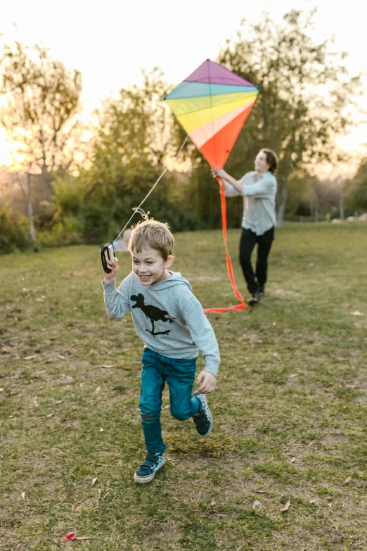 a young boy running with a kite in a field, sydney park, with a kid, adult, ayne haag