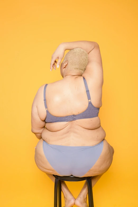 a fat woman sitting on top of a stool, inspired by Fernando Botero, trending on unsplash, wearing yellow croptop, bald lines, in style of ren hang, blue undergarments