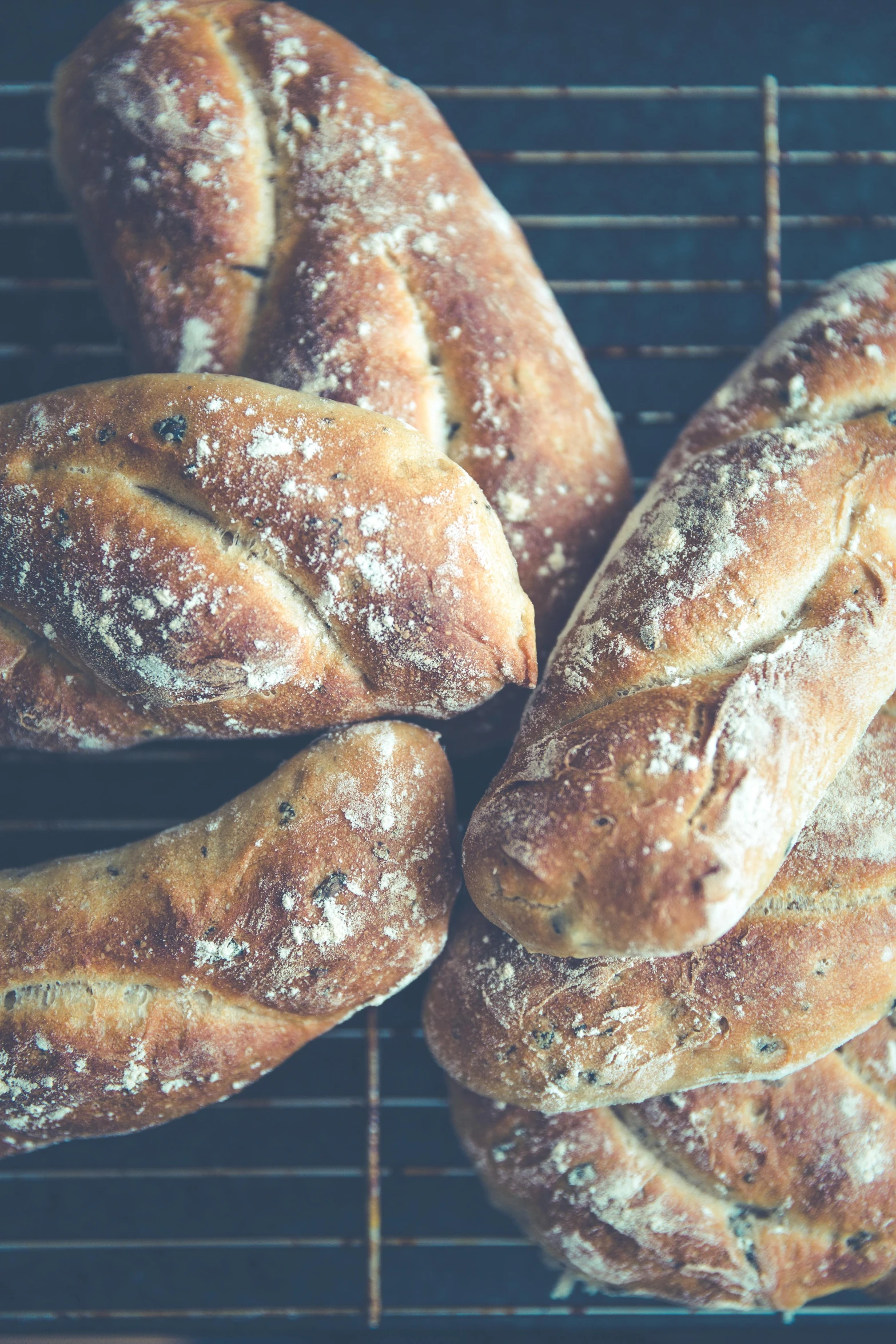 a bunch of bread sitting on top of a rack, a portrait, inspired by Richmond Barthé, pexels, weathered olive skin, gnarled fingers, mediterranean, professionally post-processed